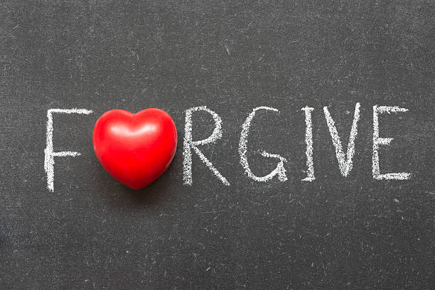 forgive word handwritten on chalkboard with heart symbol instead of O